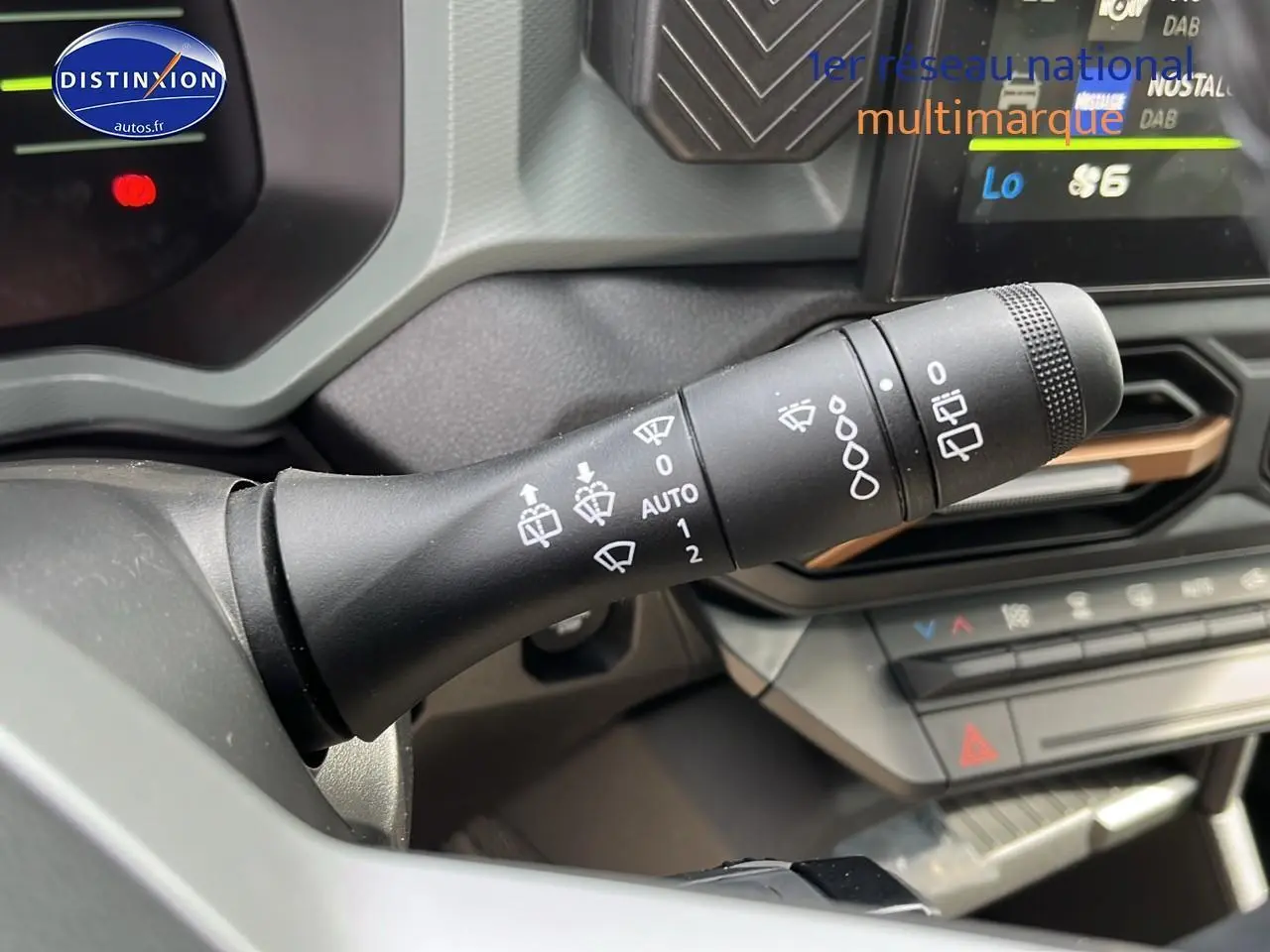 Gros plan sur la commande des essuie-glaces dans l'habitacle du Dacia Duster Sandstone 2025, tableau de bord visible.