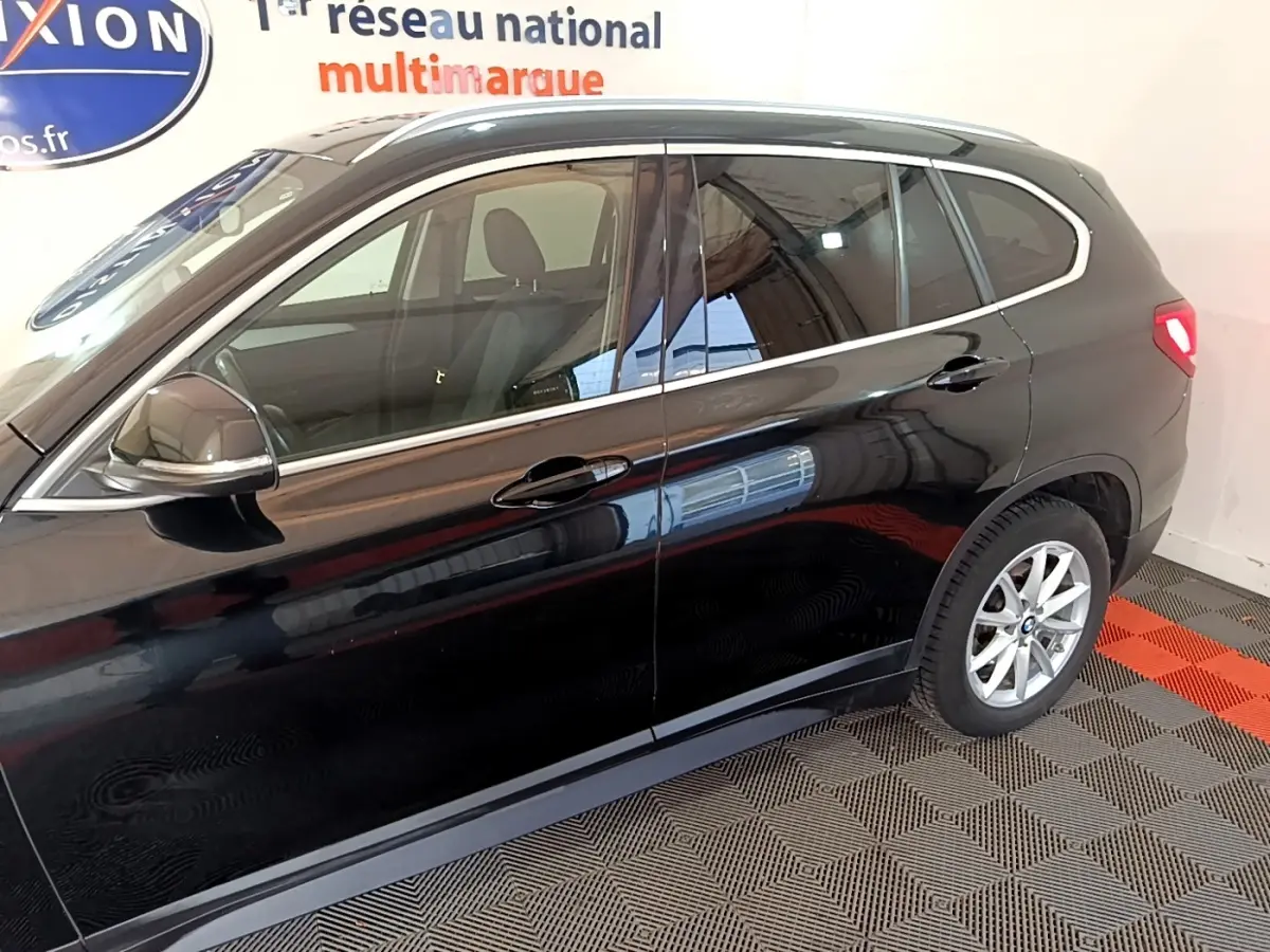 Vue latérale droite d'un BMW X1 noir 2020 avec jantes alliage et rétroviseurs électriques rabattables.