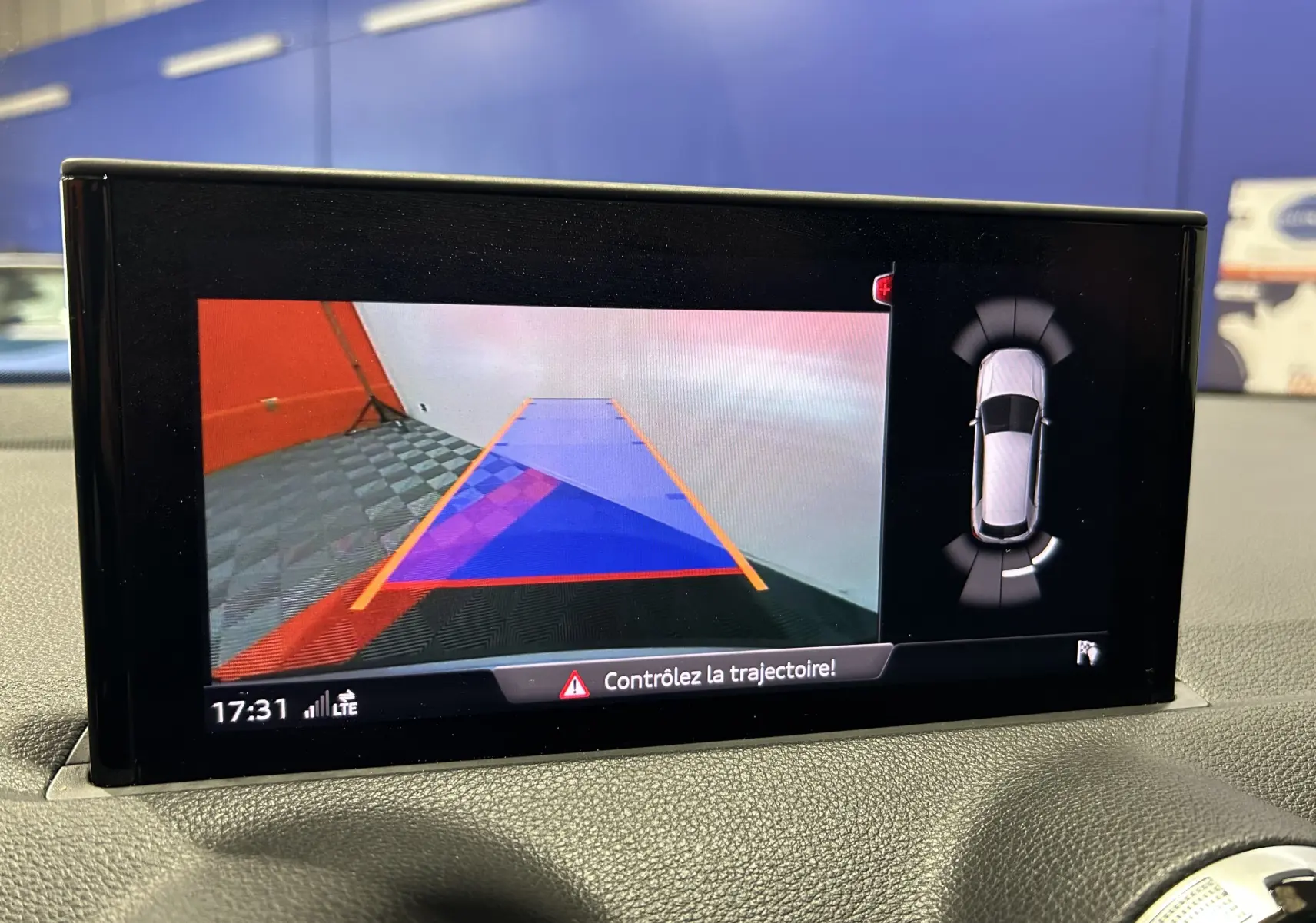 Écran de caméra de recul et capteurs de stationnement d’un Audi Q2 gris, vue intérieure du tableau de bord.