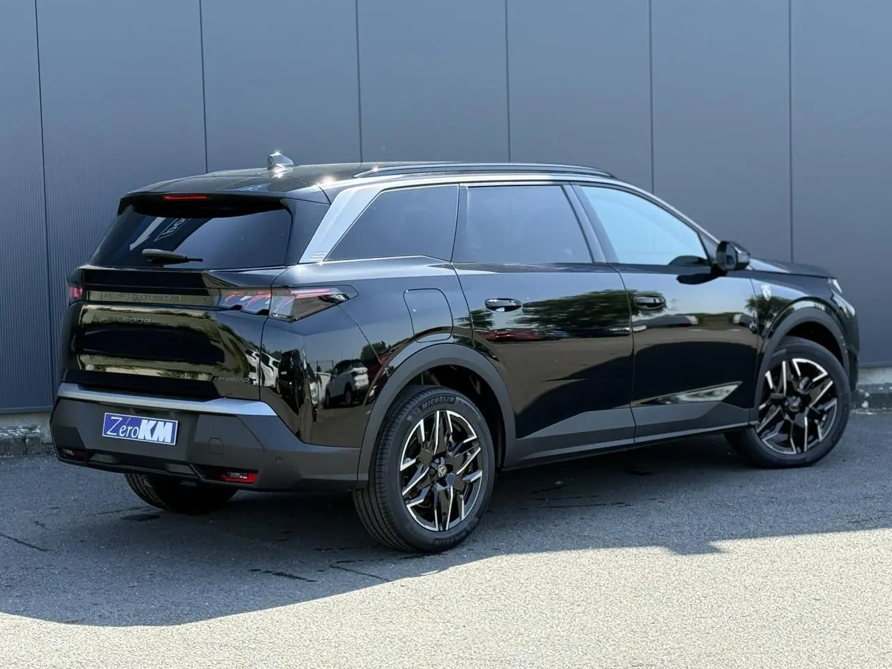 Vue 3/4 arrière droite du Peugeot 5008 Hybrid noir Perla avec jantes alliage 19'' et hayon électrique.