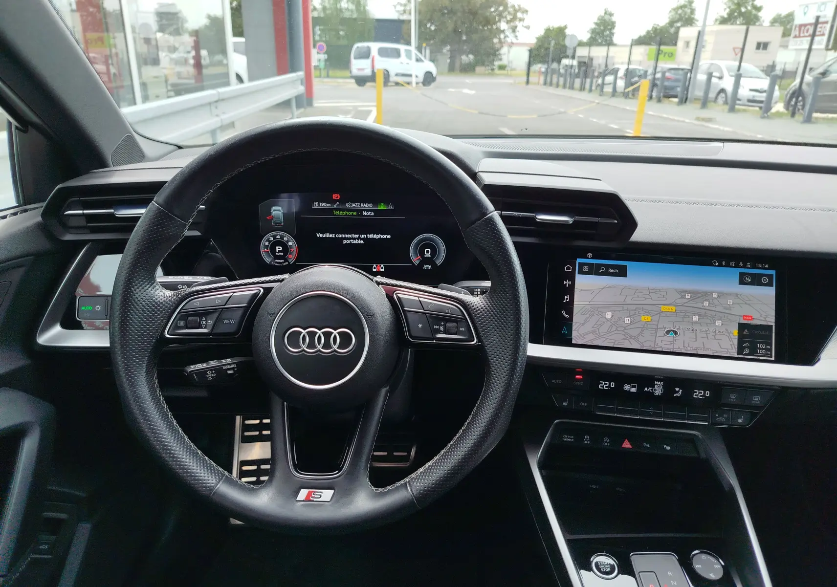 Vue intérieure centrée sur le volant S line et le tableau de bord numérique de l'Audi A3 Sportback blanc Glacier 2022.