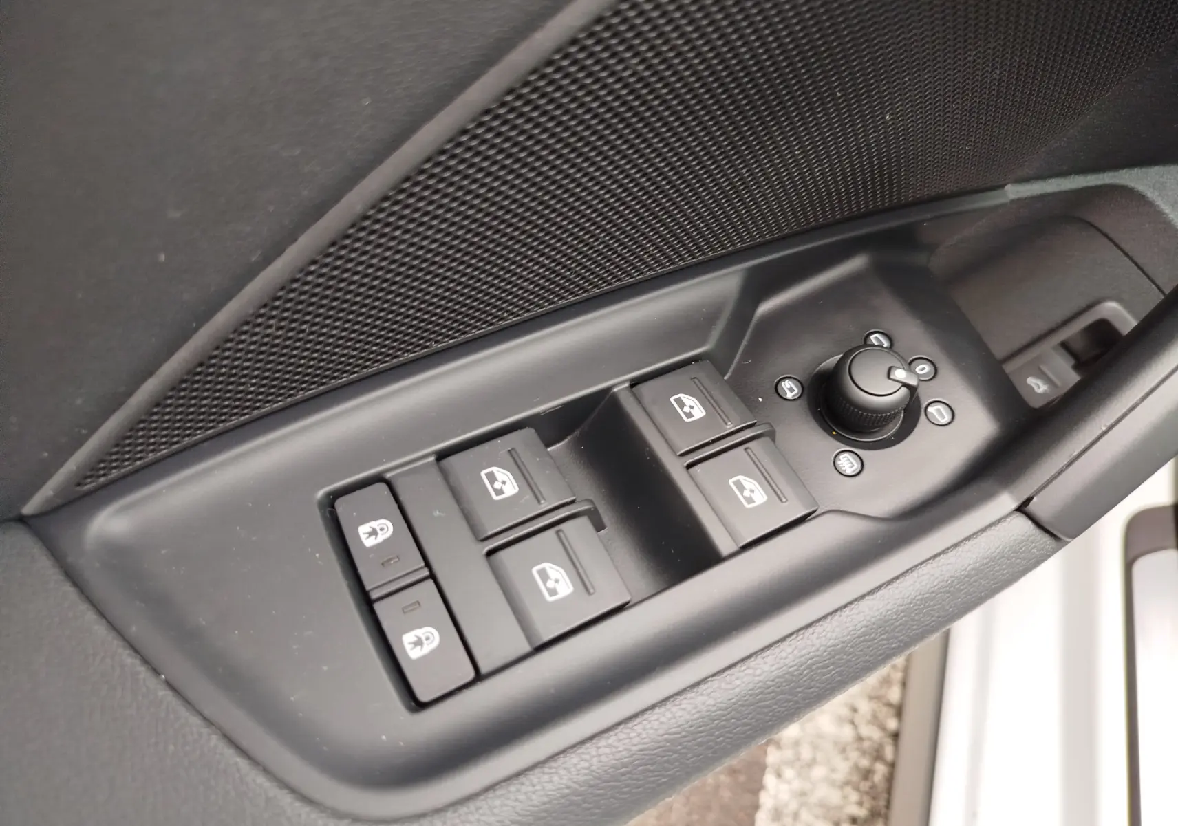 Gros plan sur les commandes de lève-vitres et rétroviseurs côté conducteur d'une Audi A3 Sportback blanc Glacier.