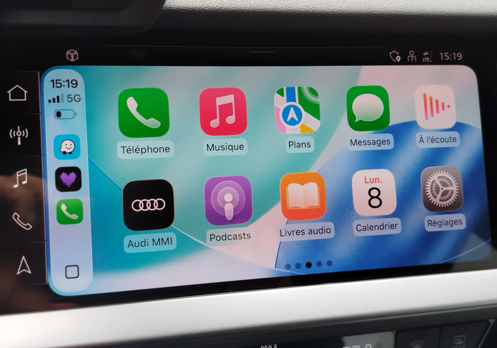 Écran tactile central de l’Audi A3 Sportback 2022 affichant l’interface Apple CarPlay colorée avec icônes d’applications.
