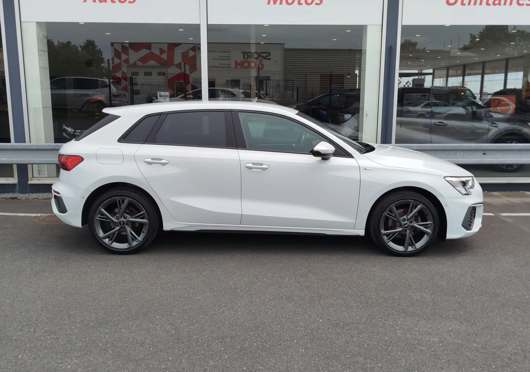Audi A3 Sportback blanc Glacier métallisé vue de profil côté gauche avec jantes alliage et badge S line.