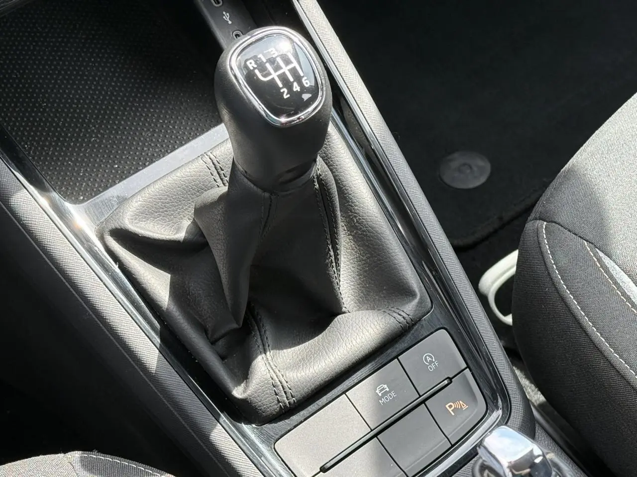 Le levier de vitesses manuel noir de la SKODA SCALA TSI 116, avec console centrale et siège tissu visible.
