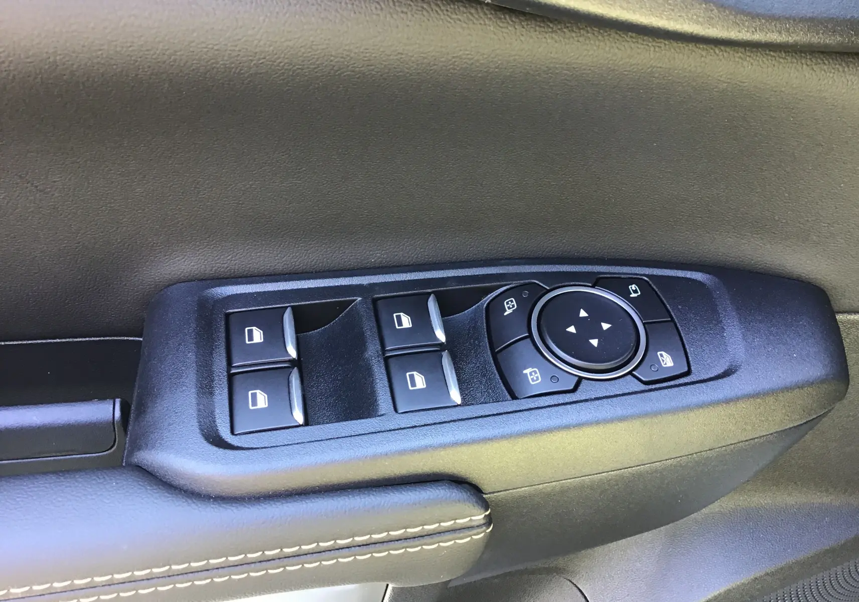 Commande des vitres et réglage des rétroviseurs sur la porte côté gauche du Ford Ranger Wildtrak gris carbone 2025.