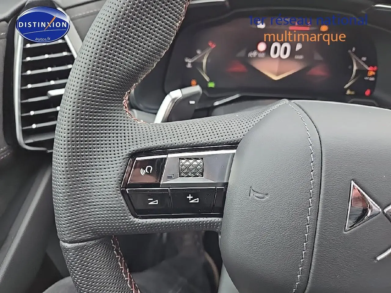 Gros plan sur le volant cuir perforé du DS7 1.5 BlueHDi 130 Pallas avec commandes intégrées et tableau de bord numérique visible.