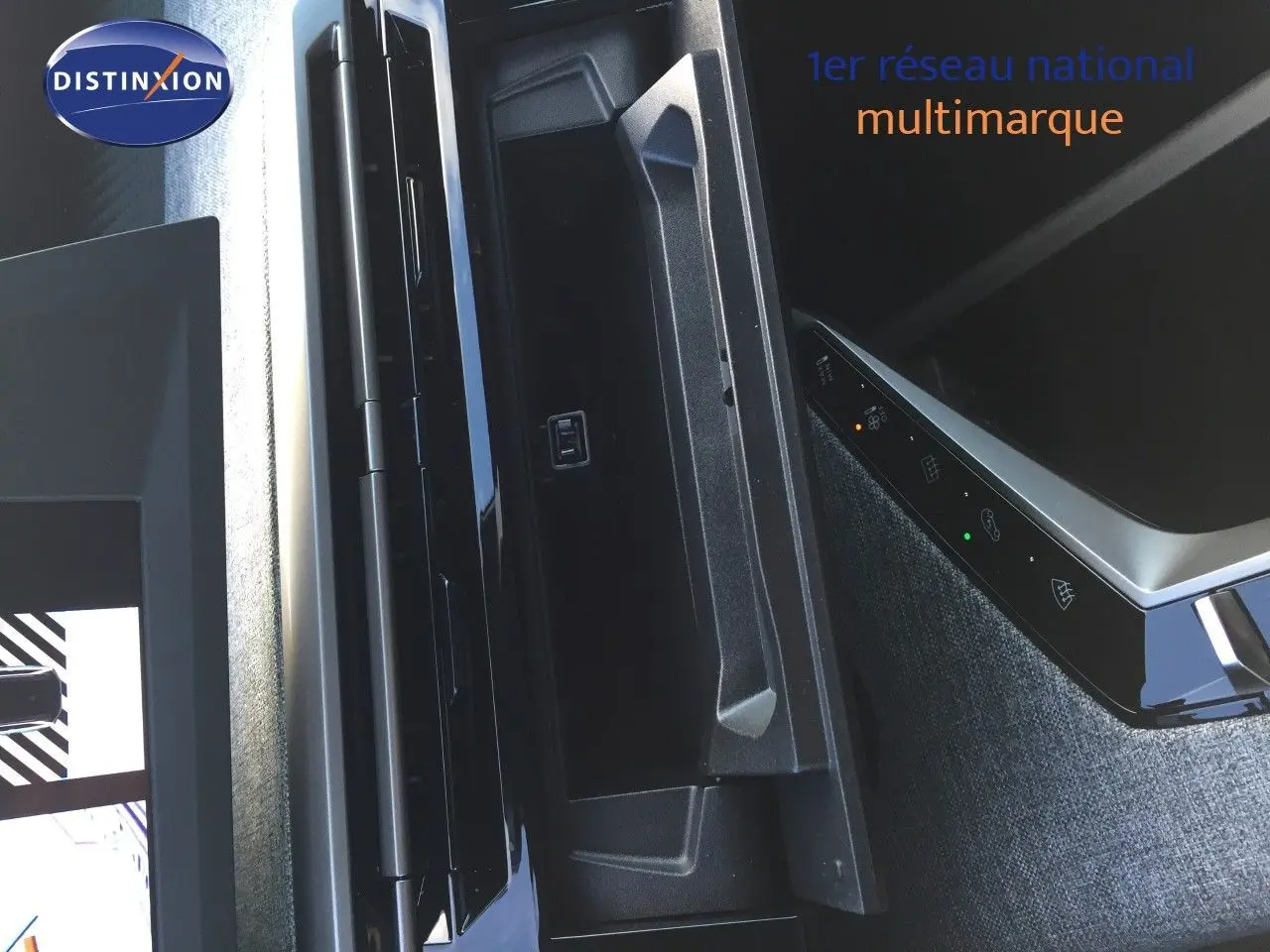 Vue rapprochée de la console centrale noire et grise du Peugeot 5008 Hybrid 2025 avec commandes tactiles éclairées.