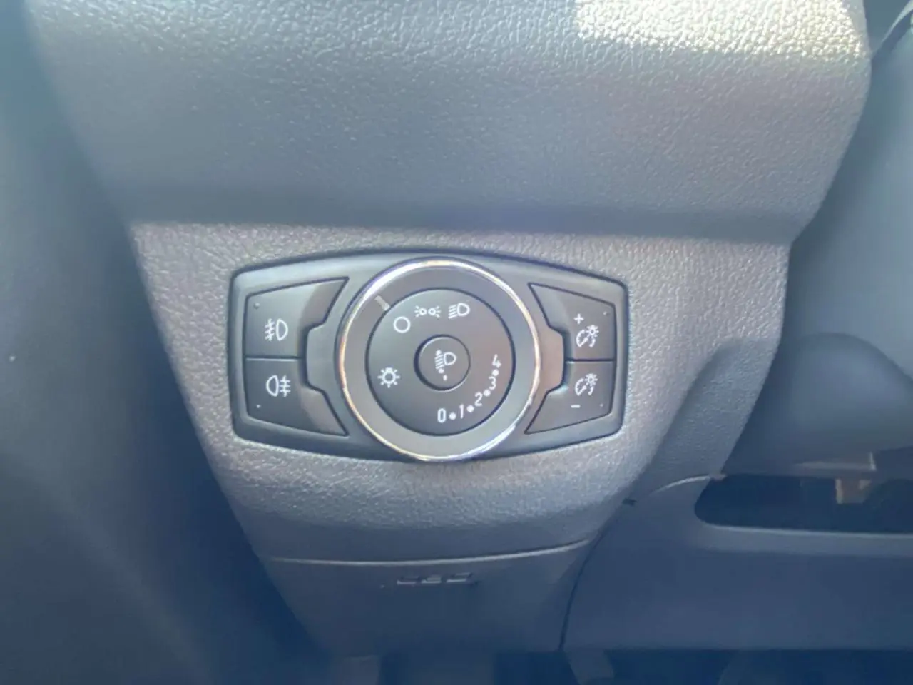 Gros plan sur le sélecteur d'éclairage du tableau de bord du Ford Tourneo Courier blanc, version 2022.