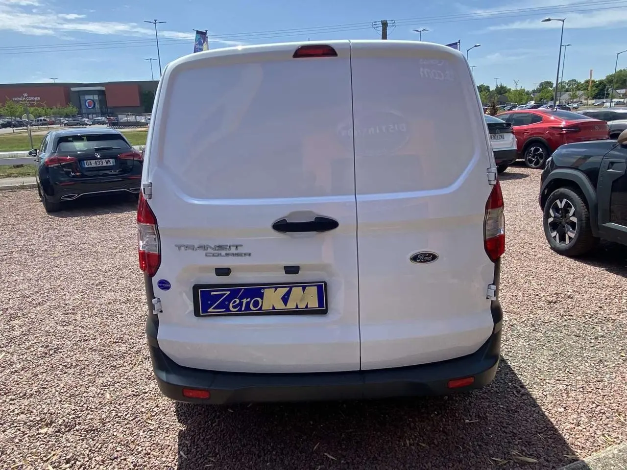 Vue arrière d'un fourgon blanc Ford Tourneo Courier 2022 avec portes battantes et plaque d'immatriculation Zéro KM.