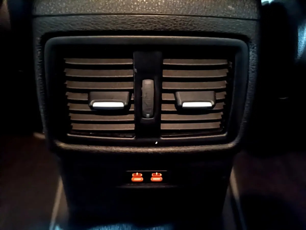 Gros plan sur les aérateurs arrière noirs et les ports USB illuminés du BMW X2 sDrive18i Lounge DKG7 2023.