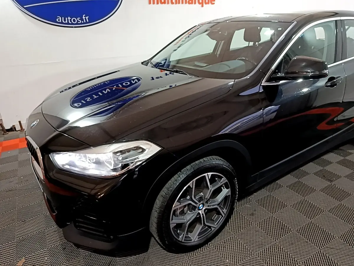 BMW X2 sDrive18i Lounge noir vue 3/4 avant droit avec phares LED et jantes alliage distinctives.