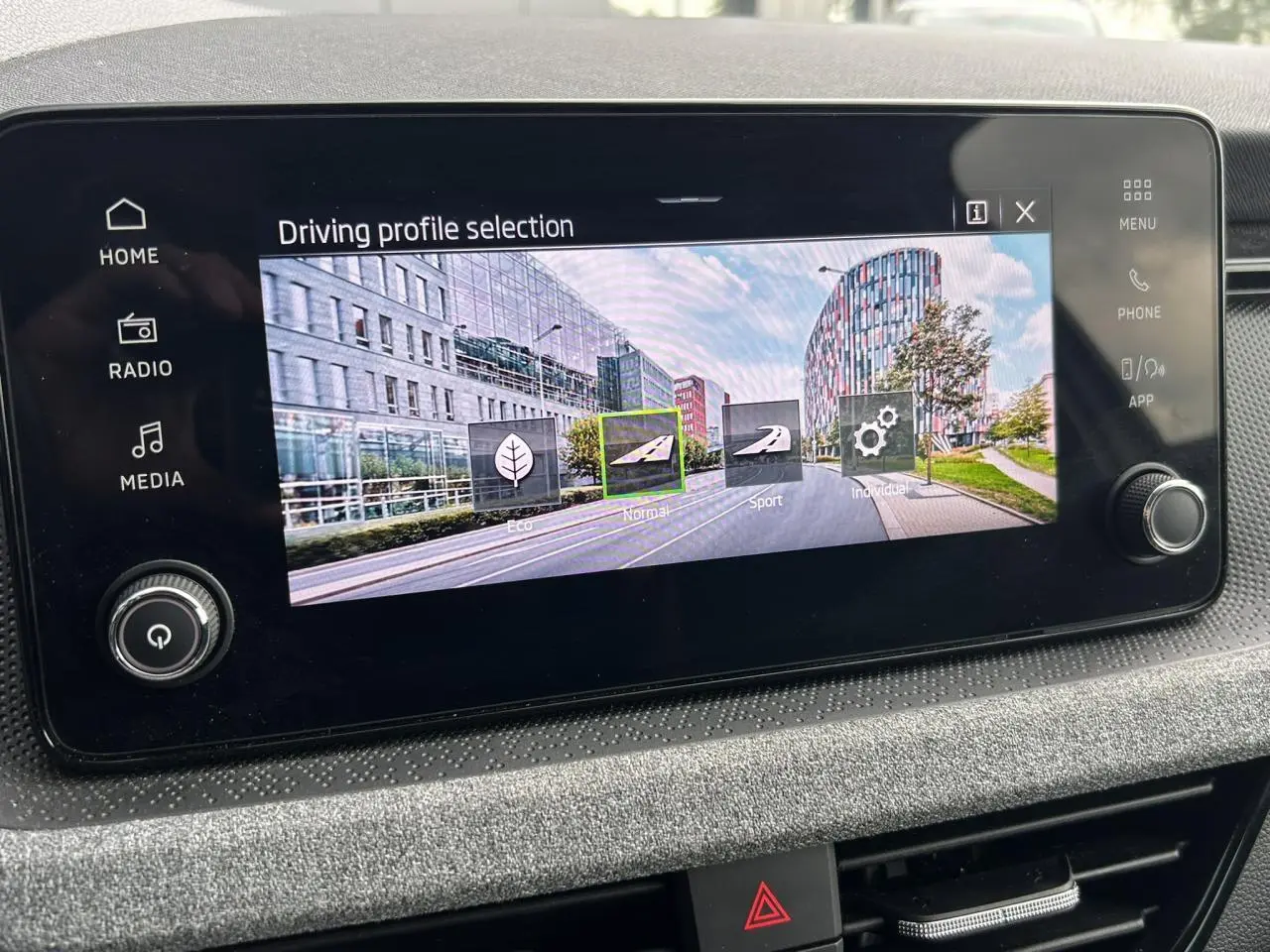 Écran tactile central de la Skoda Scala TSI 116 blanc, affichant les modes de conduite en intérieur.
