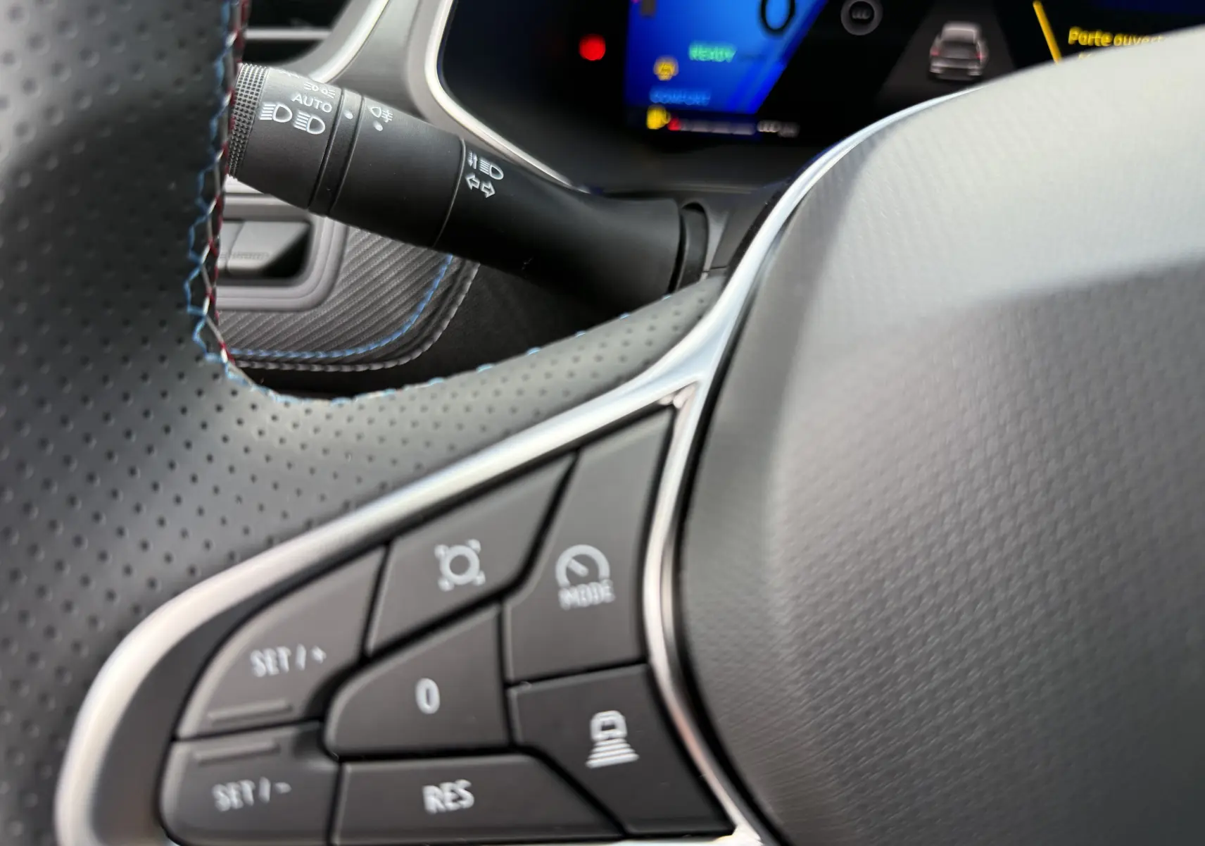 Gros plan sur le volant perforé et les commandes multifonctions du Renault Symbioz Esprit Alpine E-Tech 2026, intérieur noir.