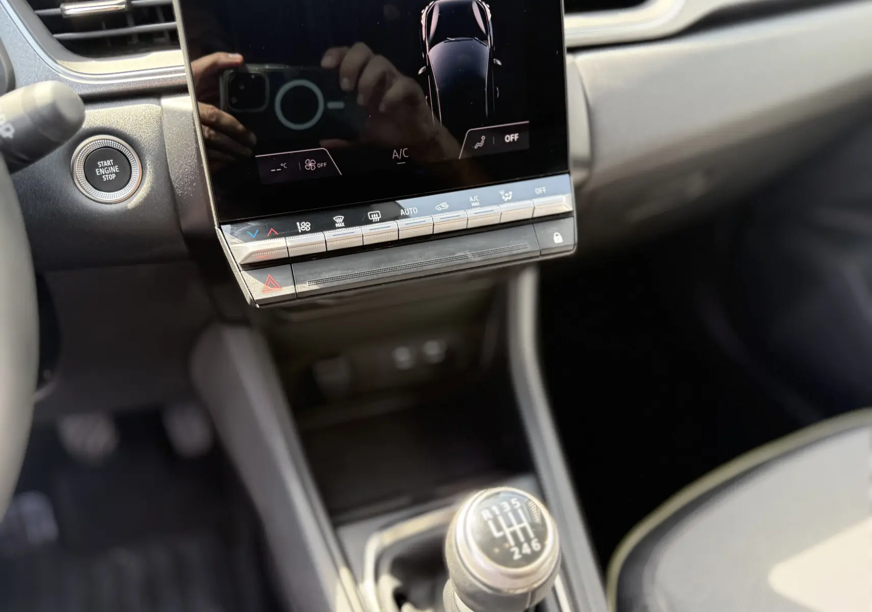 Vue rapprochée de la console centrale du Renault Captur 2025 avec levier de vitesses manuel et écran tactile noir.