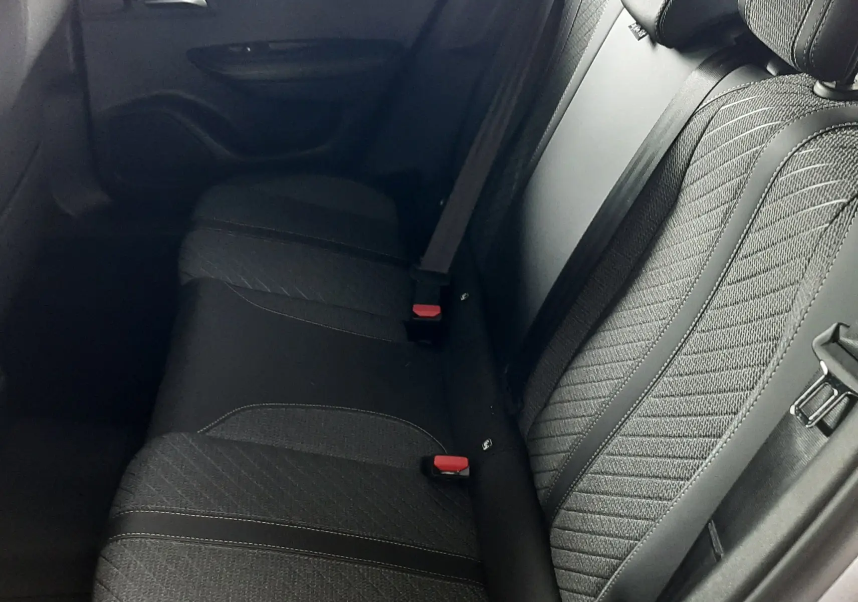 Vue latérale droite de la banquette arrière en tissu noir avec ceinture de sécurité, intérieur du Peugeot 2008 gris Artense.