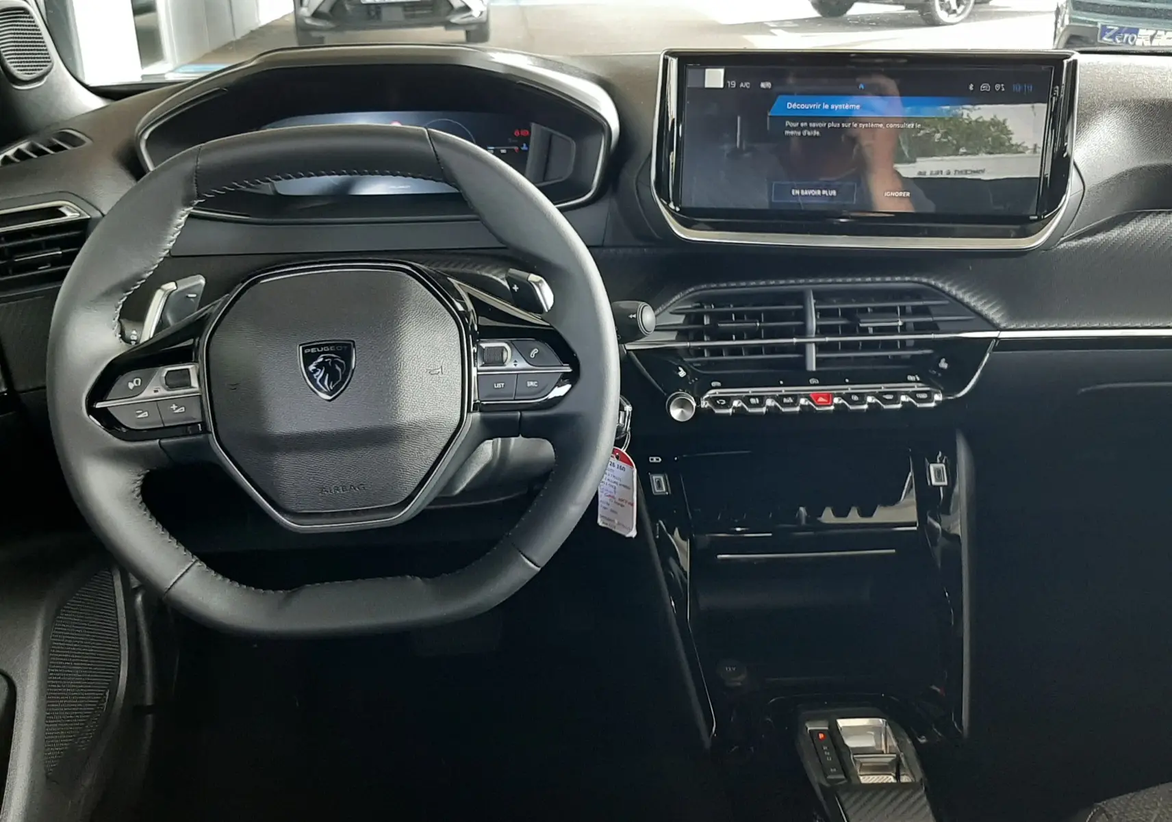 Intérieur noir du Peugeot 2008 1.2 Hybrid 145ch Allure 2025, vue frontale sur le volant et l'écran tactile central.