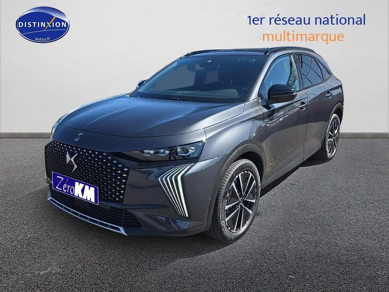 DS7 gris titane en 3/4 avant droit, mettant en valeur sa calandre distinctive et ses phares LED fins.