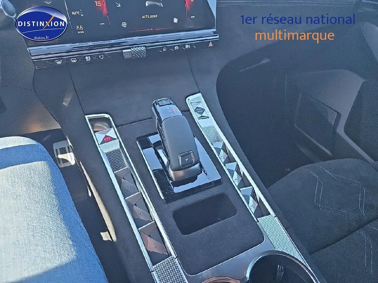 Vue rapprochée de la console centrale du DS7 gris titane 2025, avec levier de vitesse et boutons en chrome.