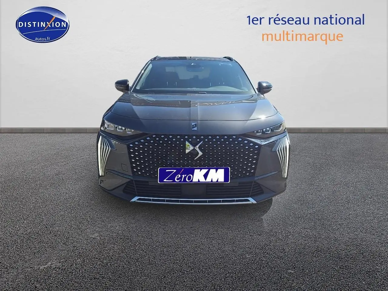 Vue frontale du DS7 gris titane 2025 avec calandre distinctive et feux LED verticaux allumés.