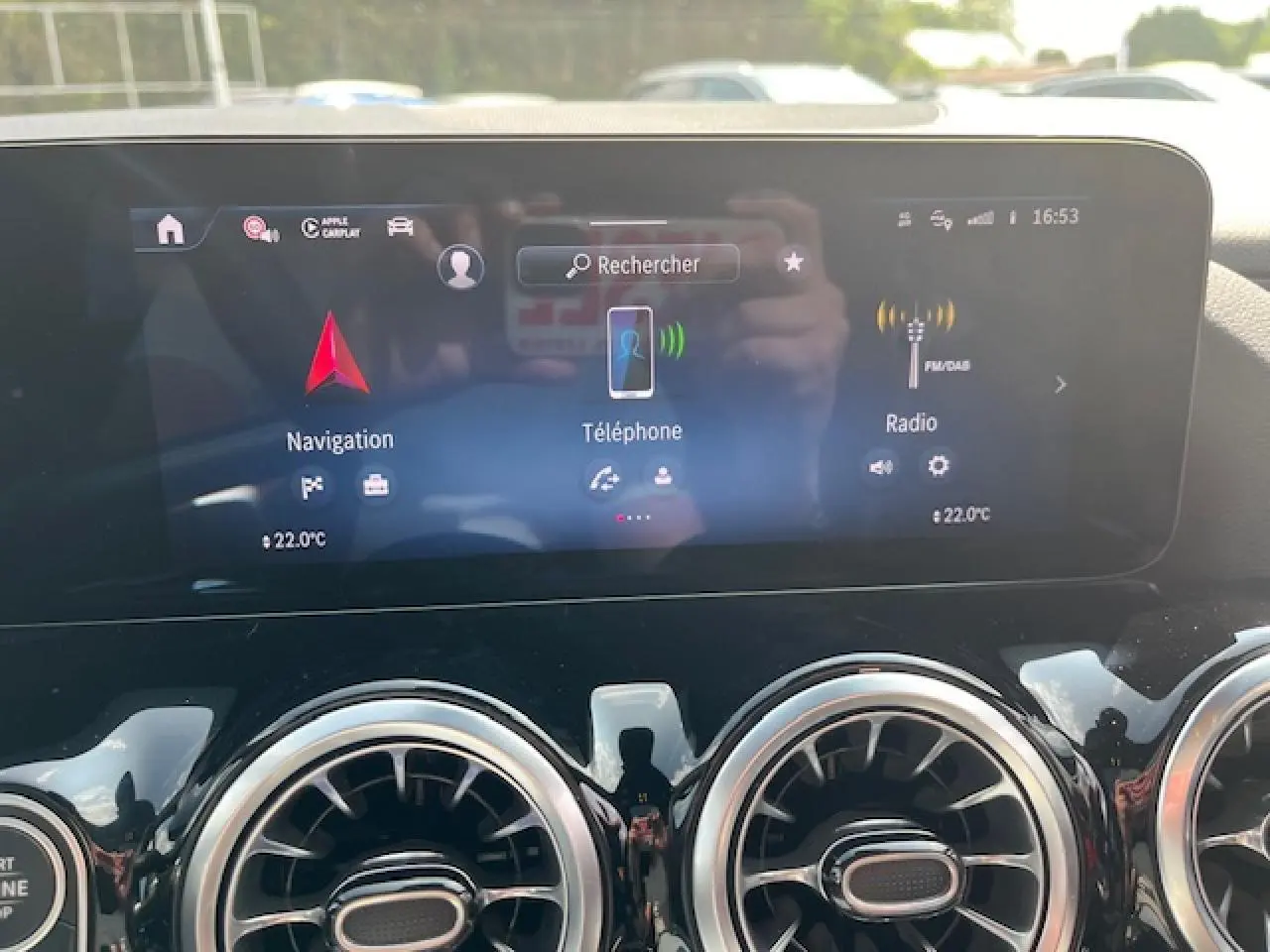 Écran tactile central du Mercedes GLA 250 e hybride 2024 affichant navigation, téléphone et radio, avec aérateurs ronds chromés.