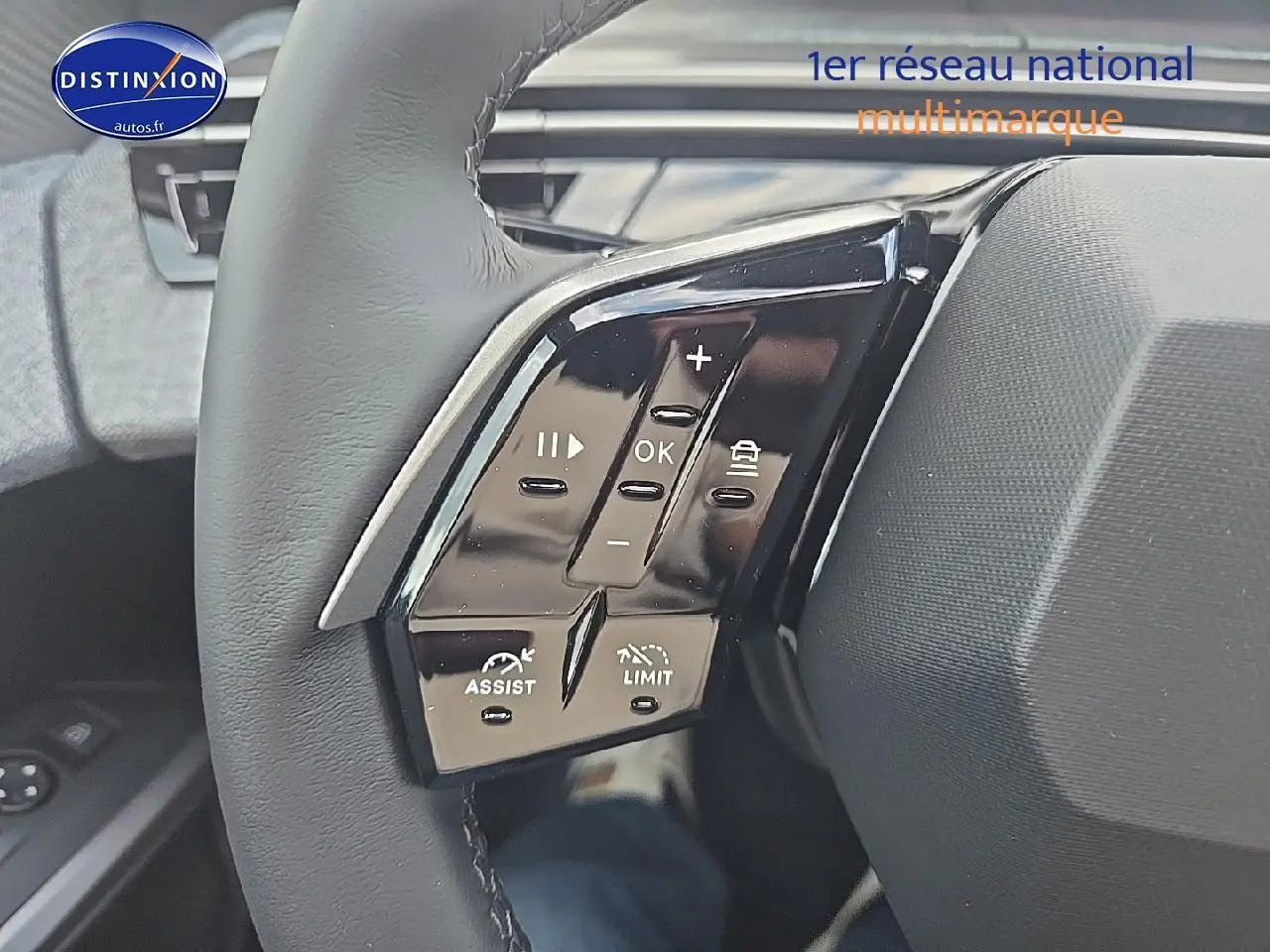 Gros plan sur les commandes multifonctions à gauche du volant cuir du Peugeot 3008 noir 2025 hybride.