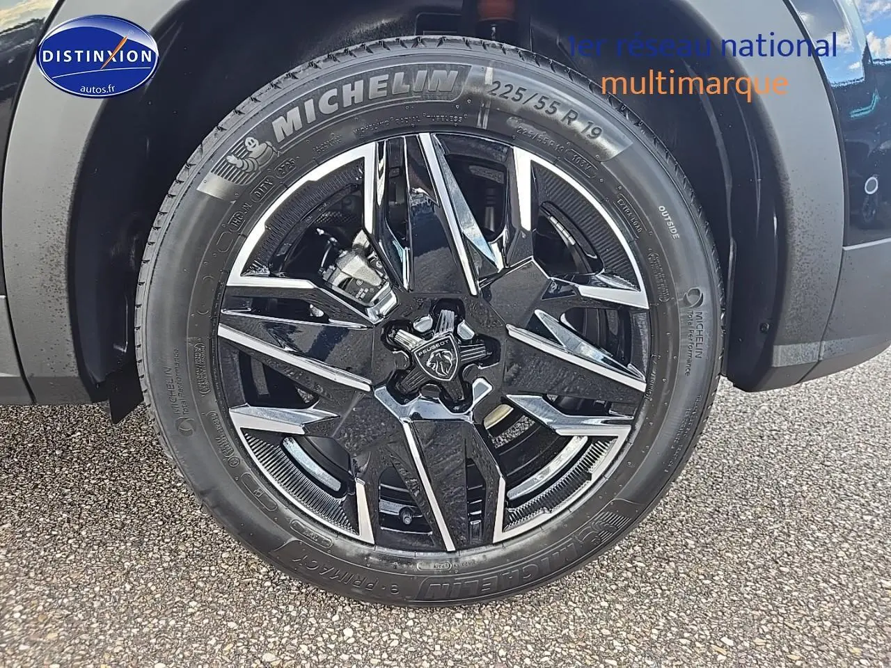 Gros plan sur la jante alu noire et chromée avec logo Peugeot d'un 3008 noir, pneu Michelin 225/55 R19 visible.