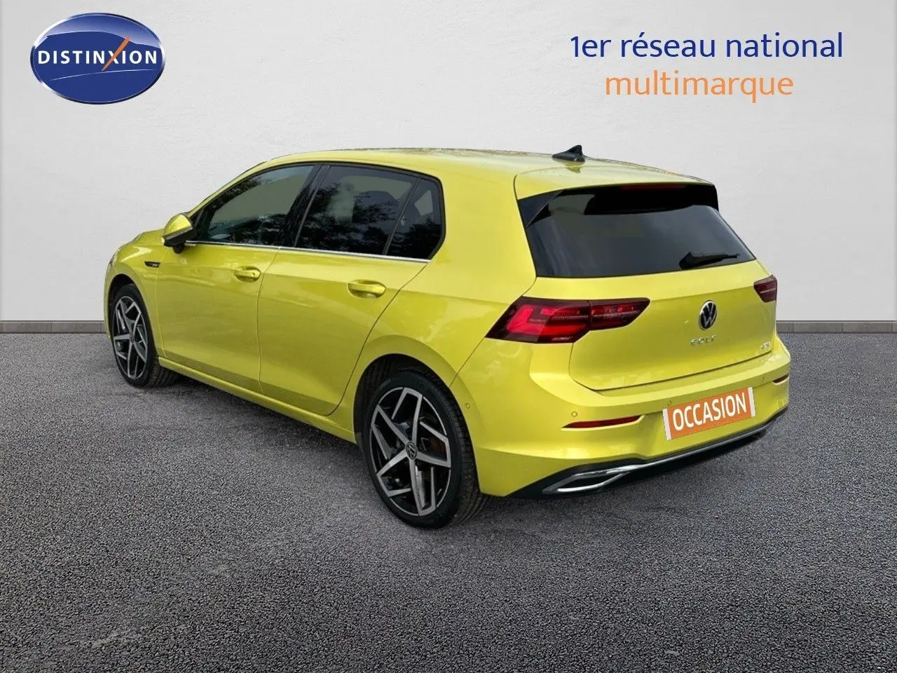 Vue 3/4 arrière droite d'une Volkswagen Golf jaune vif avec jantes alliage et vitres teintées.