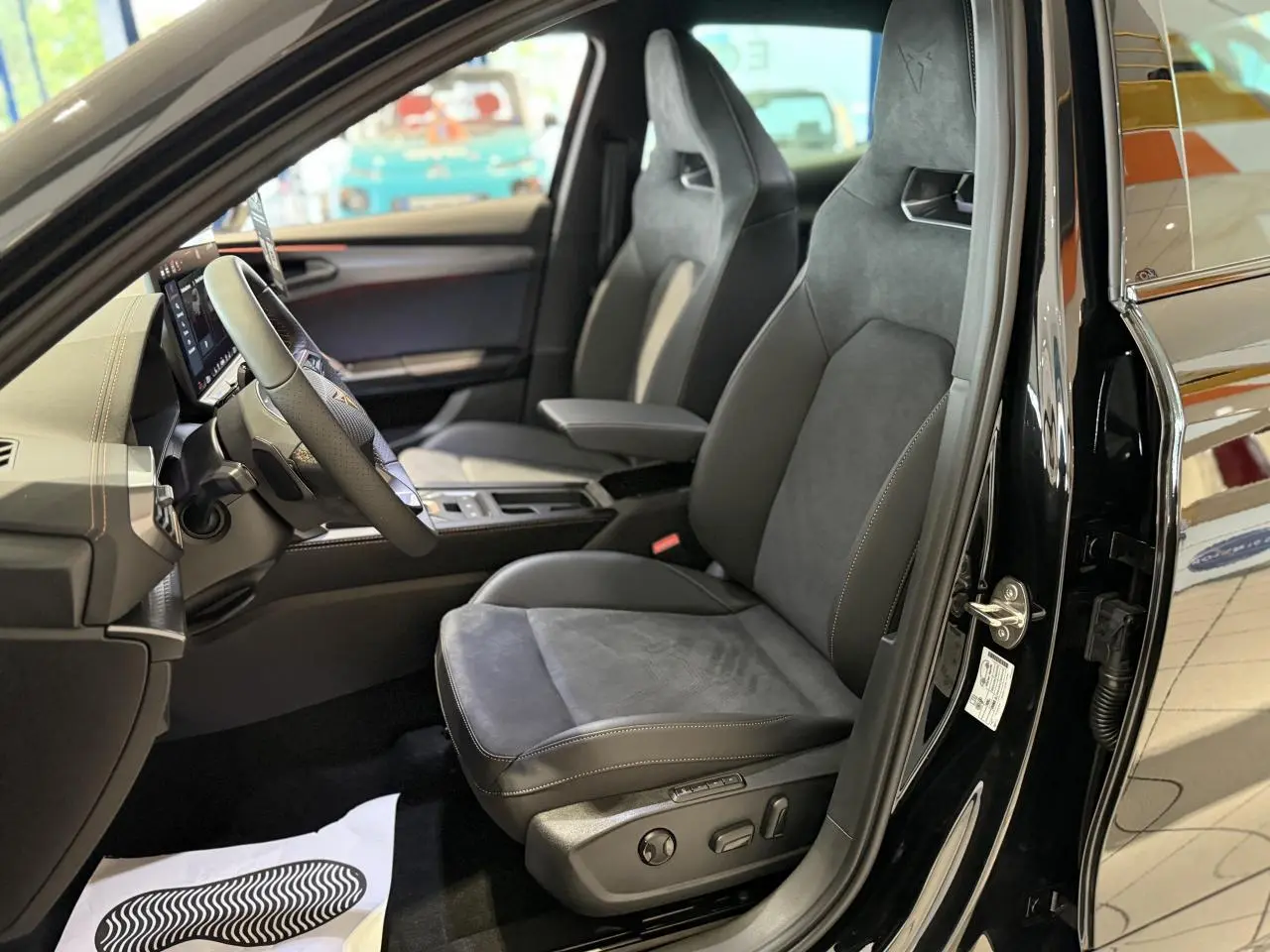 Vue intérieure côté conducteur de la CUPRA Formentor noir Night, sièges baquets cuir et alcantara avec surpiqûres cuivrées.