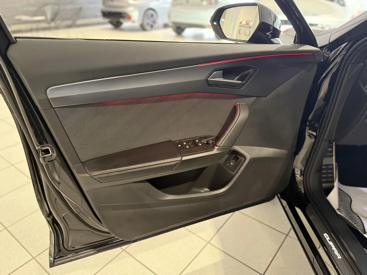 Vue rapprochée de la contre-porte côté gauche noire avec surpiqûres cuivrées et poignée intégrée du CUPRA Formentor Noir Night 2025.