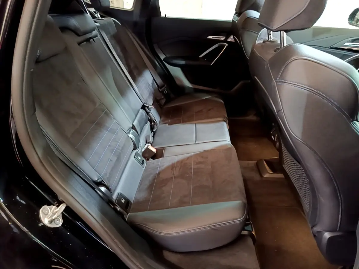 Vue intérieure côté gauche des sièges arrière en tissu et cuir noir du BMW X1 xDrive23i M Sport 2023.