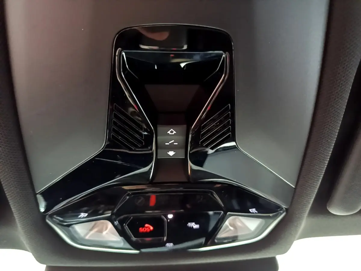 Vue en contre-plongée du plafonnier noir brillant avec boutons SOS et commandes d’éclairage intérieur du BMW X1 2023.