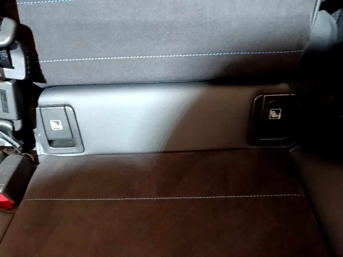 Détail de la banquette arrière noire avec commandes de rabattement des sièges sur une BMW X1 xDrive23i M Sport 2023.
