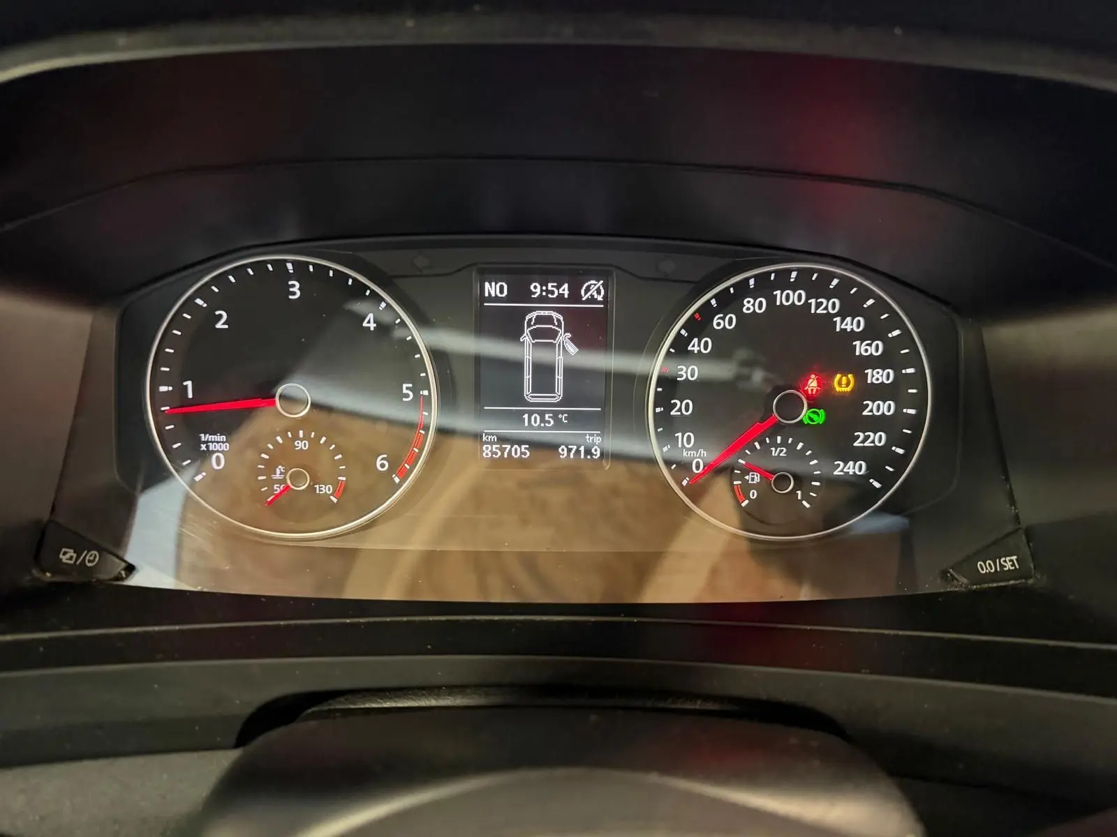 Vue rapprochée du tableau de bord du Volkswagen Transporter blanc, affichant compte-tours, vitesse et écran central numérique.