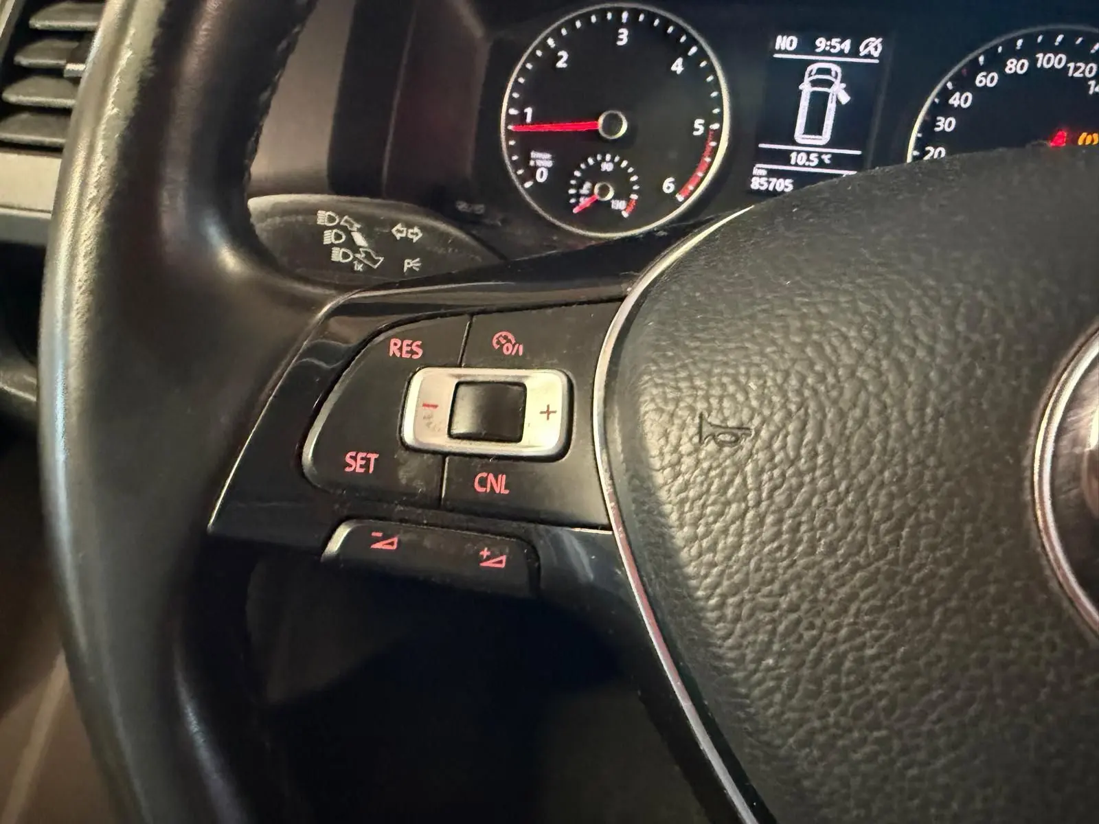 Gros plan sur le volant noir du Volkswagen Transporter 2019, avec commandes de régulateur de vitesse et tableau de bord en arrière-plan.