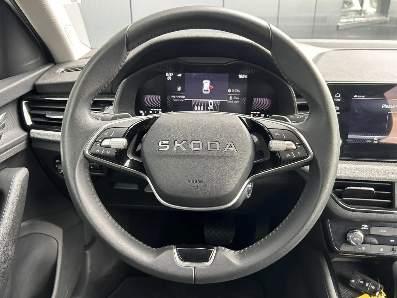 Vue frontale du volant cuir noir multifonctions SKODA dans l'habitacle moderne du SCALA blanc Candy 2025.
