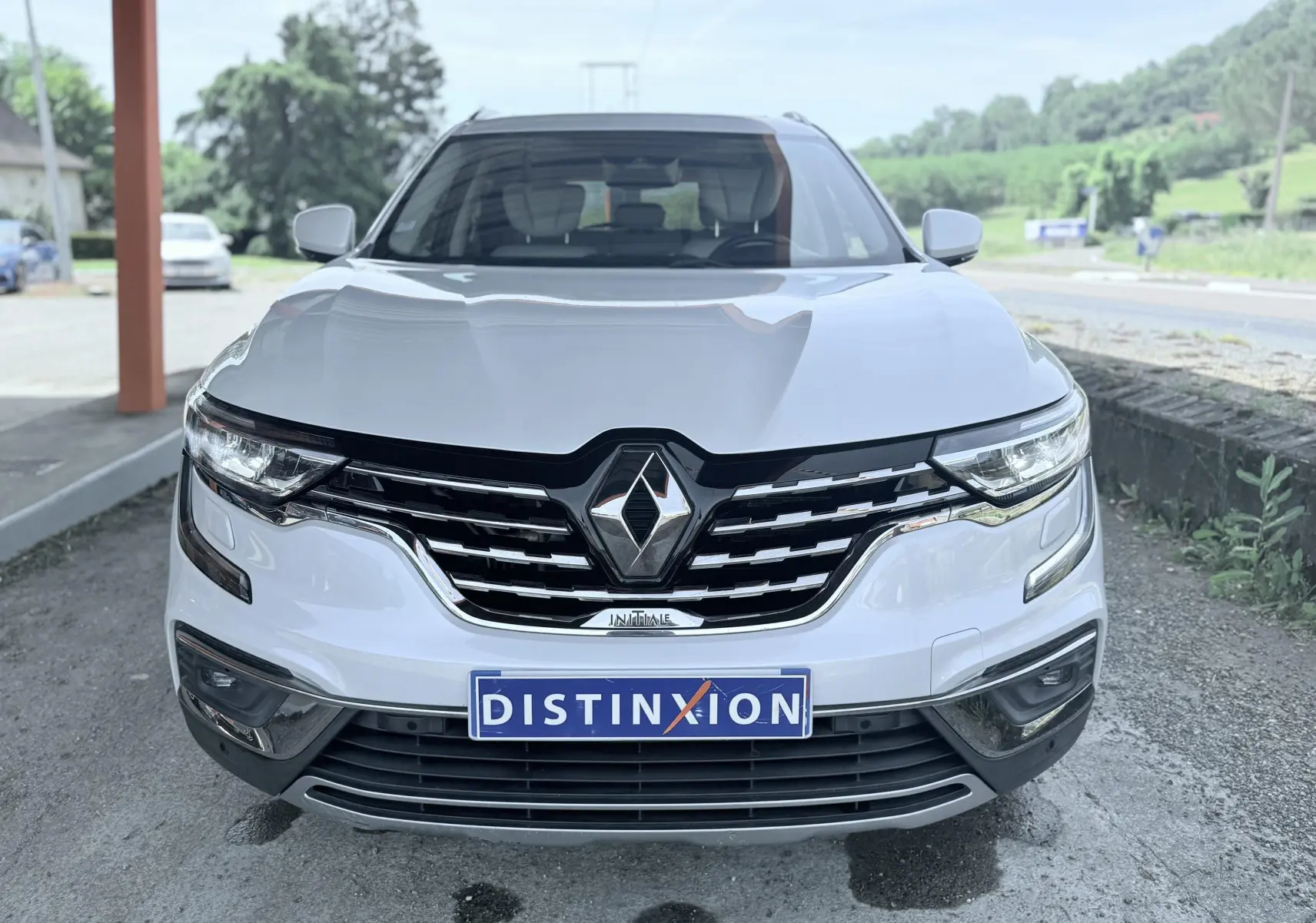 Vue avant d'un Renault Koleos blanc 2021 avec calandre chromée et logo Renault bien visible.