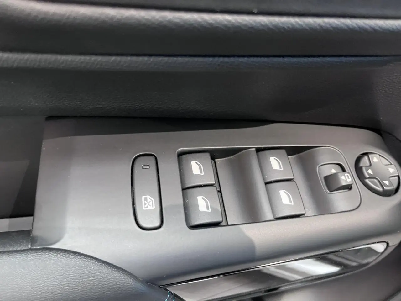 Gros plan sur les commandes de lève-vitres et réglages des rétroviseurs côté conducteur d'une Citroën C5 Aircross gris platinium.