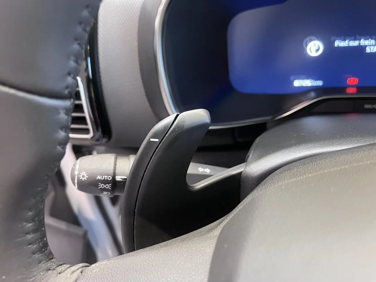 Gros plan sur la palette de changement de vitesse noire derrière le volant du Citroën C5 Aircross gris platinium.