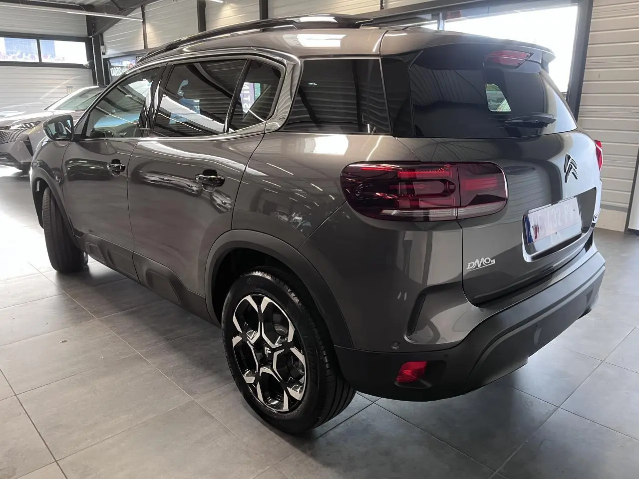 Vue 3/4 arrière droite du Citroën C5 Aircross gris platinium avec jantes alliage bi-ton et vitres surteintées.