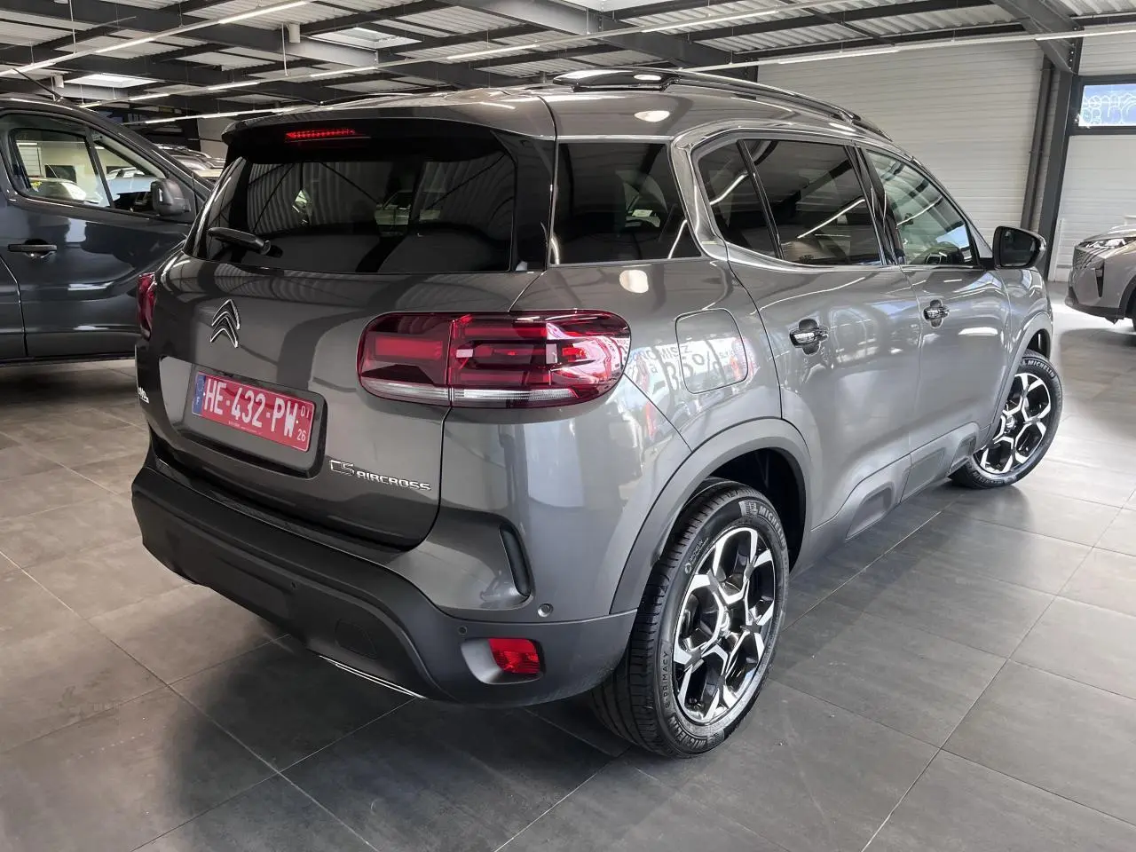 Vue 3/4 arrière droite d'un Citroën C5 Aircross gris platinium avec jantes alliage bi-ton et feux arrière LED 3D.