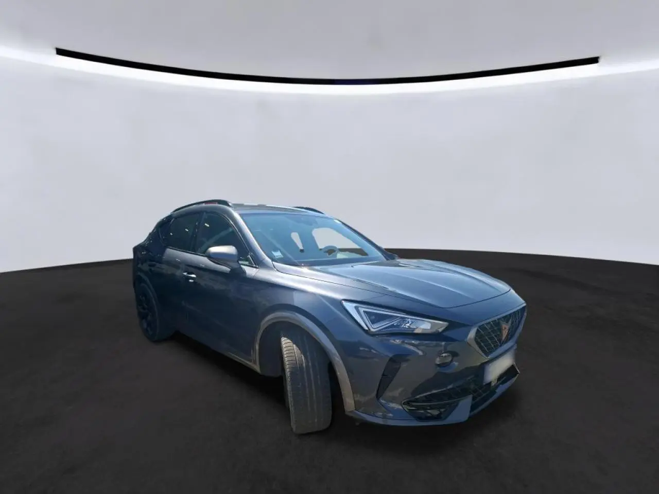 Vue 3/4 avant droit d'un CUPRA Formentor gris magnétique avec jantes alliage noires et détails noirs contrastants.