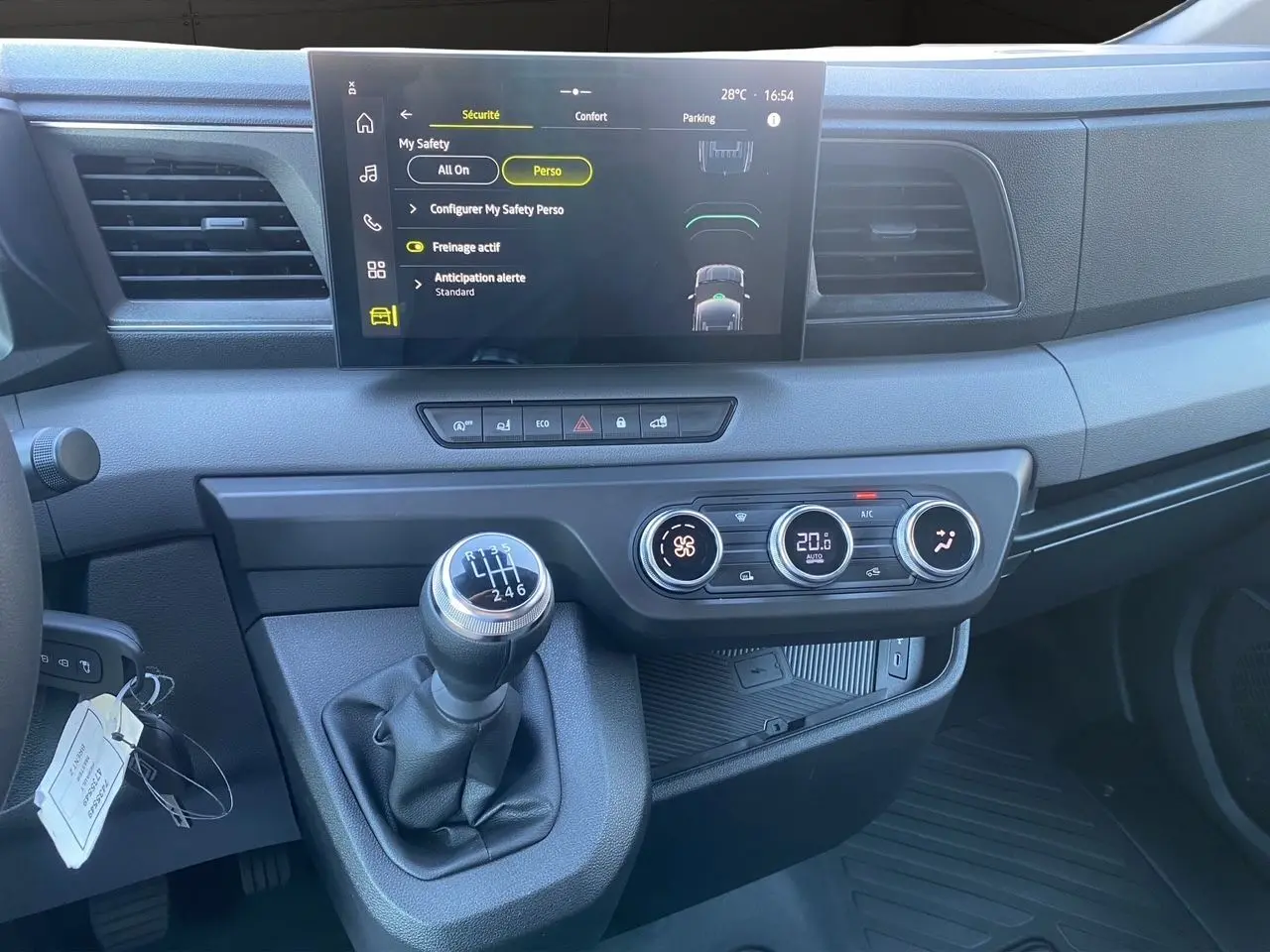 Vue rapprochée du tableau de bord du Renault Master 2025 avec écran tactile, climatisation et levier de vitesses manuel.