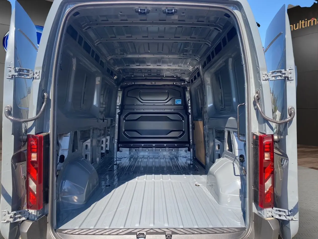 Vue arrière du Renault Master gris urbain 2025 avec portes ouvertes dévoilant l'espace de chargement vide et métallique.