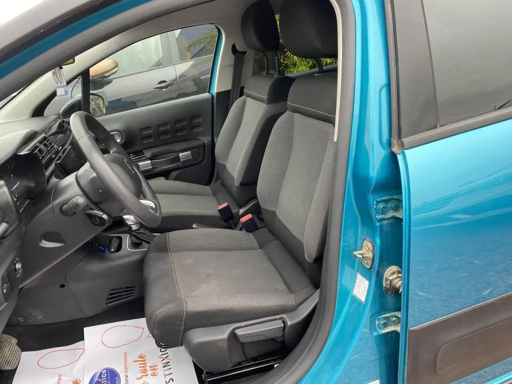 Intérieur avant côté conducteur d'une Citroën C3 2023 bleu Spring Azul, sièges tissu gris et tableau de bord noir.