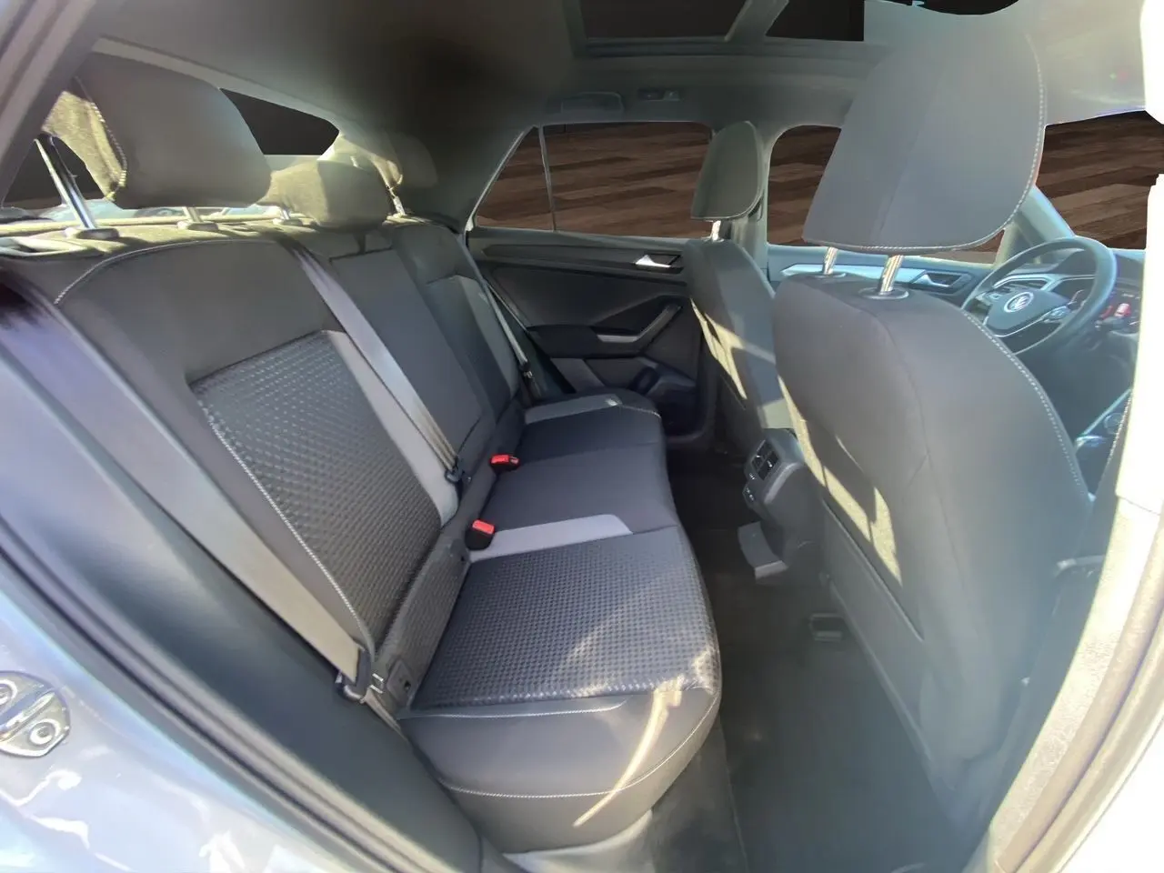 Vue intérieure du siège arrière côté gauche d'un Volkswagen T-Roc silver white 2021 avec toit ouvrant panoramique.