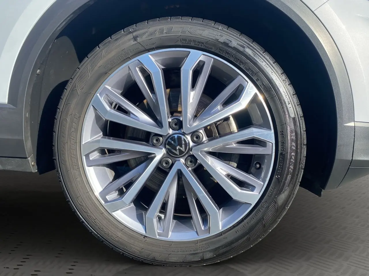 Gros plan sur la jante alu 18 pouces argentée du Volkswagen T-Roc Silver White, mettant en valeur le logo VW central.