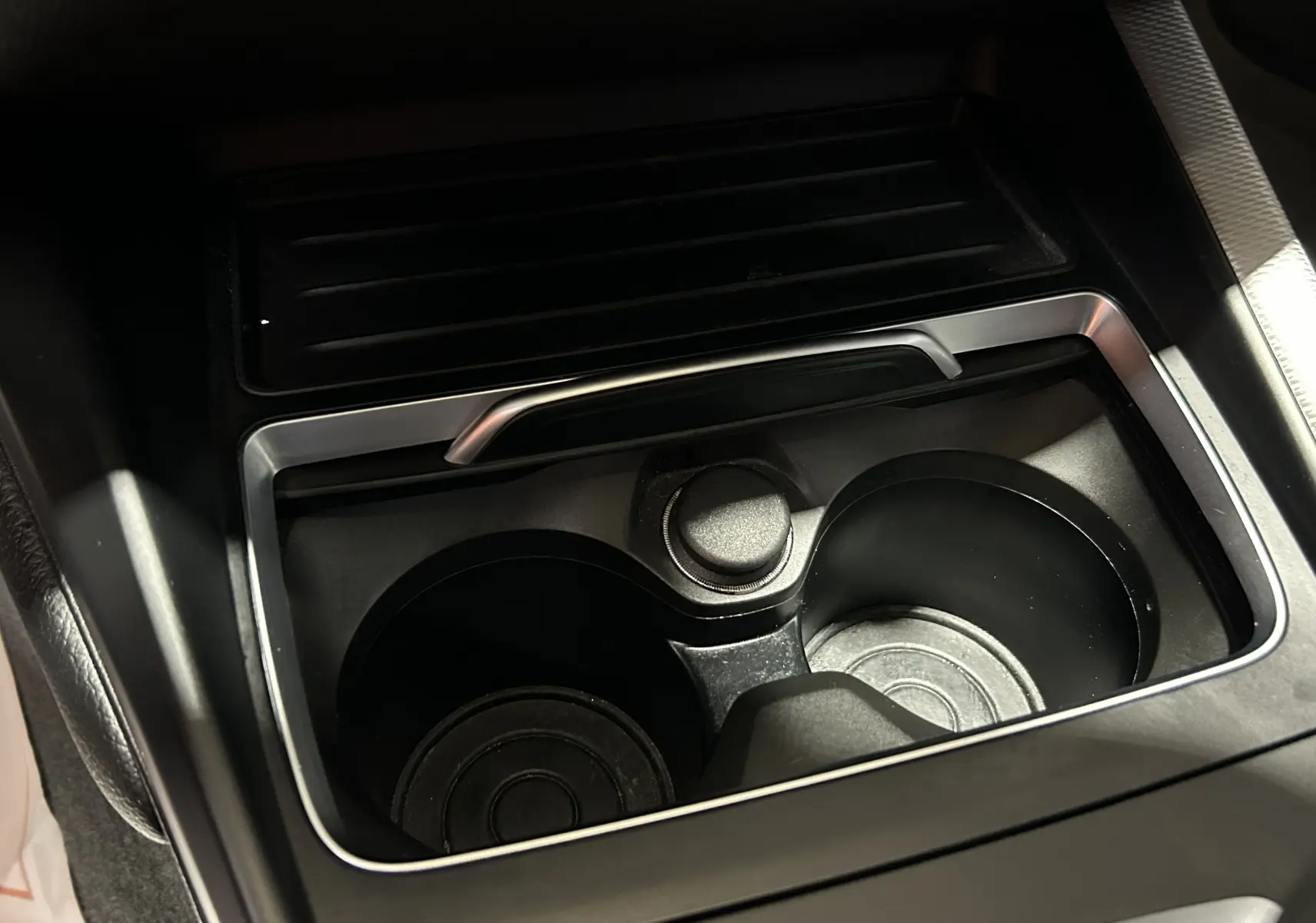 Gros plan sur le porte-gobelets central noir de la BMW Série 1 120iA 2019 avec finition M Sport.