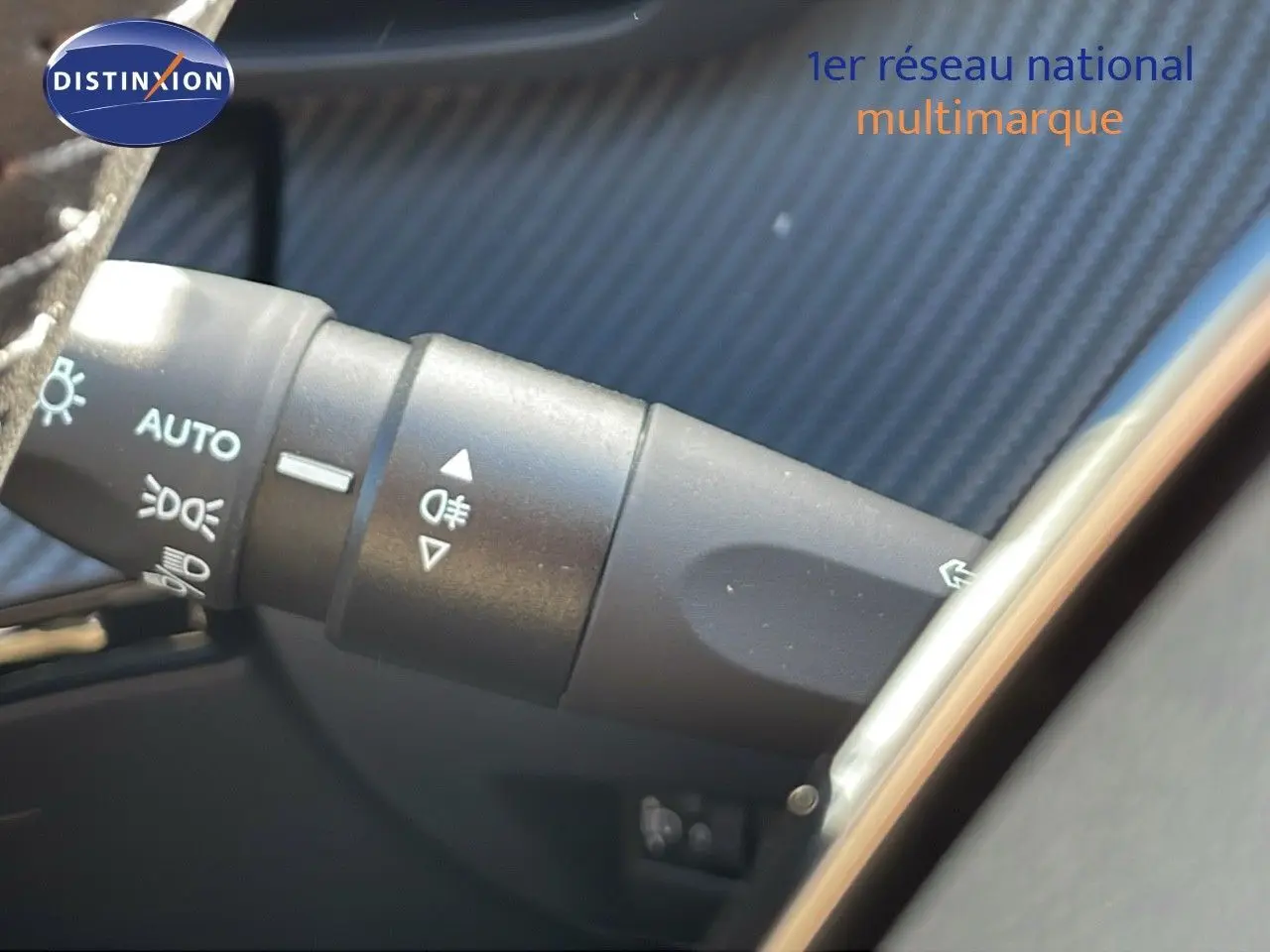 Détail du commodo d’éclairage côté gauche dans l’habitacle du Peugeot 2008 bleu Vertigo Metal 2024.