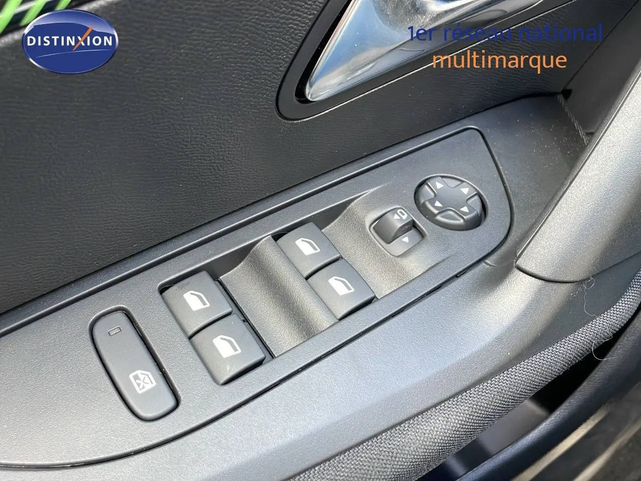 Gros plan sur les commandes des vitres et rétroviseurs côté conducteur de la Peugeot 2008 1.2 PureTech 2024, intérieur noir.